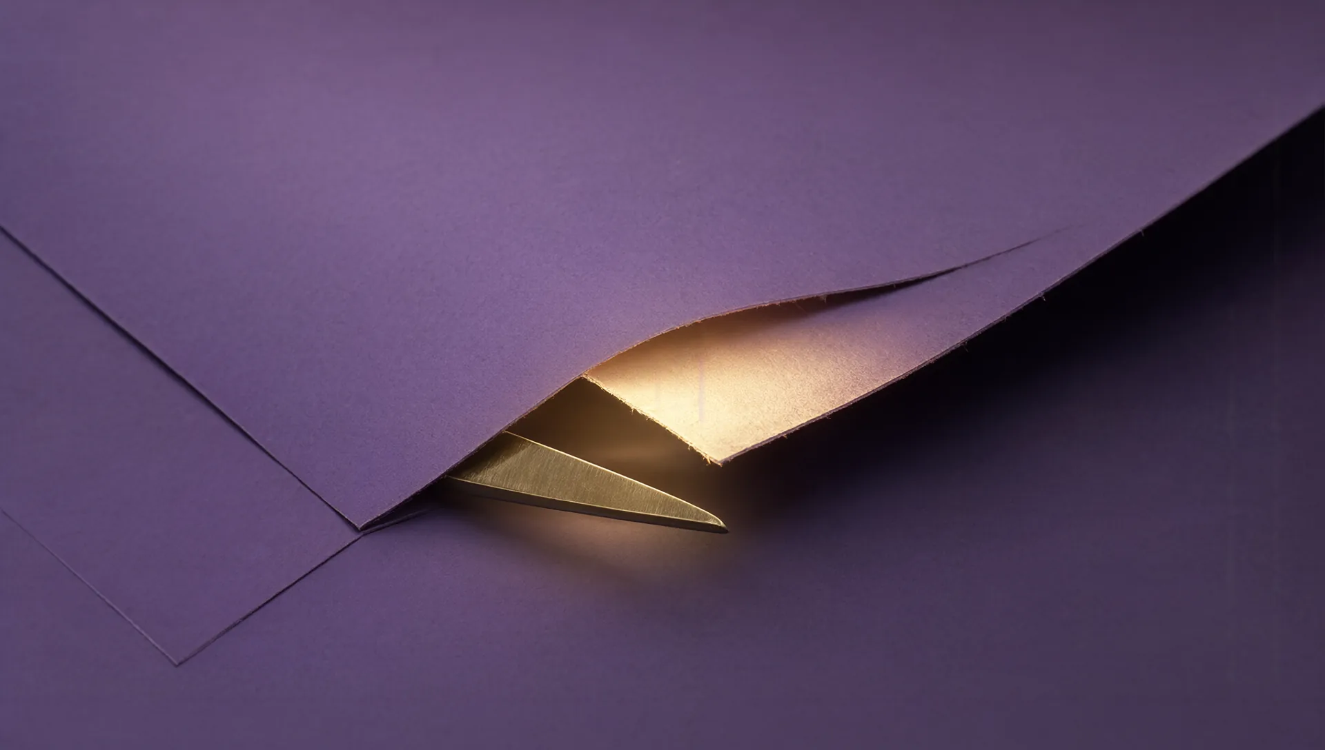 Delle forbici tagliano un foglio di carta viola; dalla fessura del taglio filtra una luce dorata.